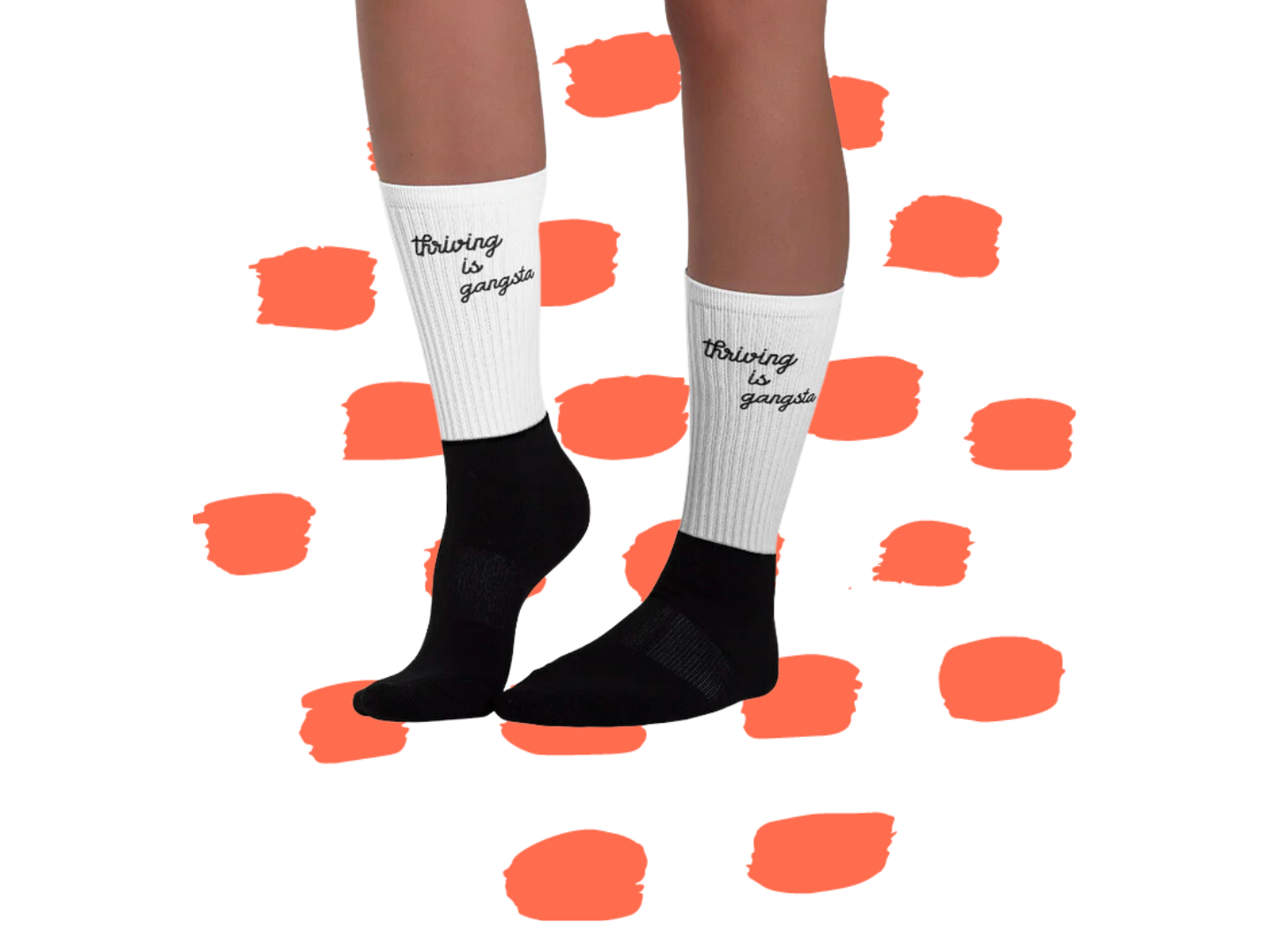 A pair of legs wearing Thrive Gang's "Thriving is Gangsta" black and white socks.