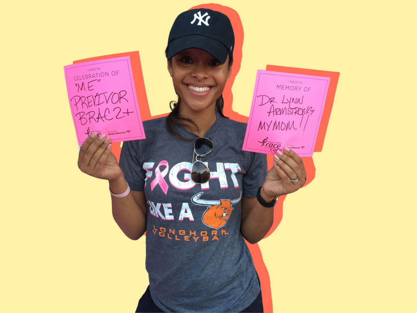 Ashley poses at a Breast Cancer Awareness event with handwritten signs